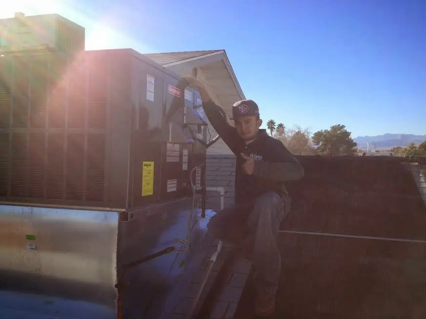 HVAC technician performing HVAC Inspection on a rooftop unit in Bensley